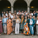A large group of people holding award certificates